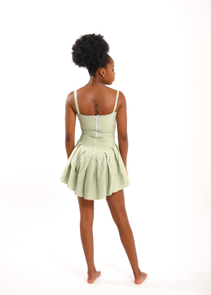 Black woman in mint fitted dress with flared bottom